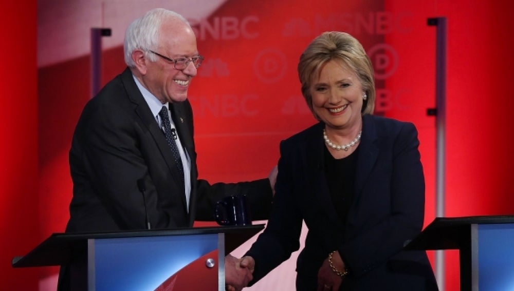 Hillary Clinton y Sanders se saludan.