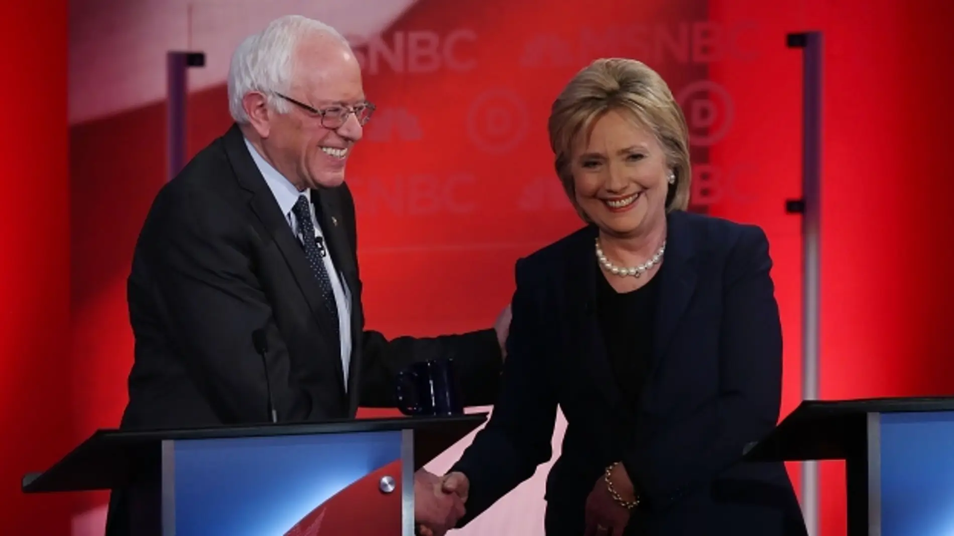 Hillary Clinton y Sanders se saludan.