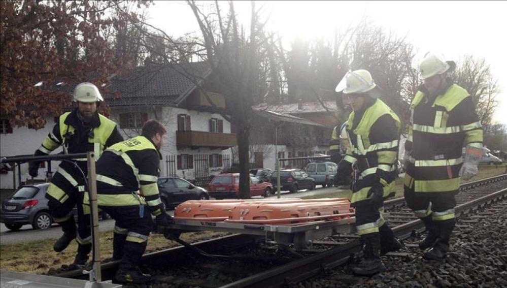   Bomberos trabajan en el lugar donde se ha producido el choque de dos trenes en Bad Aibling (Alemania). 