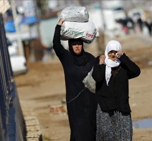 Refugiados sirios trasladan bolsas de alimentos en el paso fronterizo de Öncüpinar, en Kilis, Turquía Refugiados sirios trasladan bolsas de alimentos en el paso fronterizo de Öncüpinar, en Kilis, Turquía
