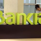 Una operaria limpia el logo de Bankia