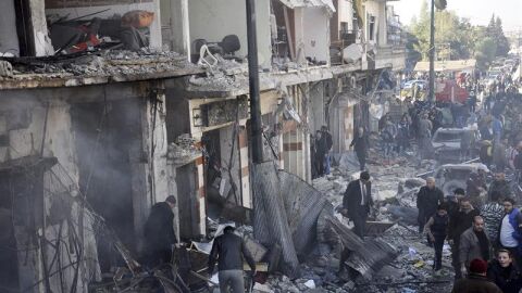 Polic&iacute;as sirios inspeccionan el lugar donde se ha producido un atentado en Homs, Siria