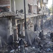 Policías sirios inspeccionan el lugar donde se ha producido un atentado en Homs, Siria
