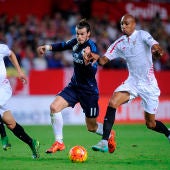 Bale entre dos jugadores sevillistas queriéndose hacerse con el balón. 