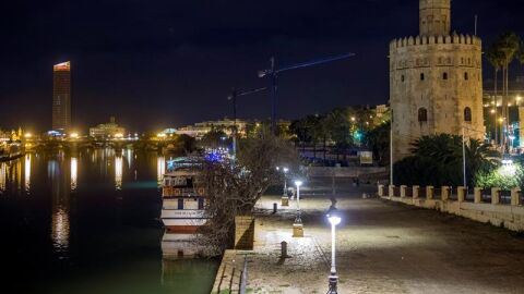 La sevillana Torre del Oro y el Puente de Triana durante el apag&oacute;n de luces que se ha realizado con motivo de 'La Hora del Planeta'