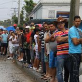 Un grupo de cubanos observa la llegada del presidente de los EEUU, Barack Obama.