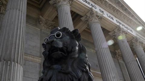 Uno de los leones de las Cortes aparece con unas gafas para conmemorar el IV centenario de la muerte de Cervantes.