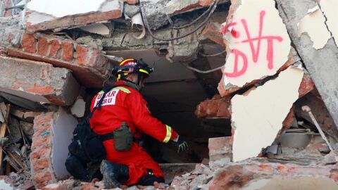 Un bombero peruano intenta escuchar una persona atrapada