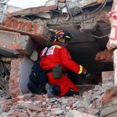 Un bombero peruano intenta escuchar una persona atrapada