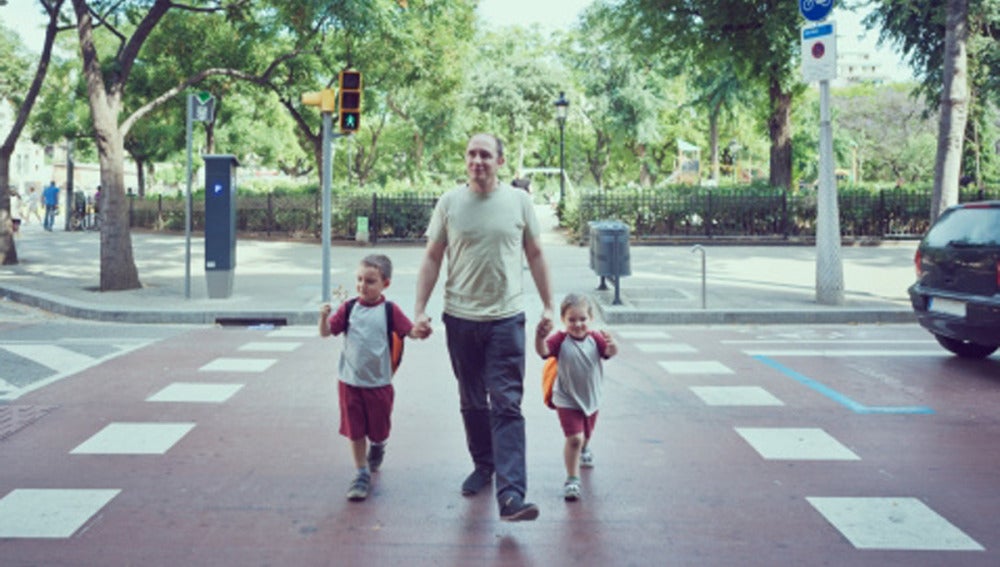 Un padre pasea con sus dos hijos