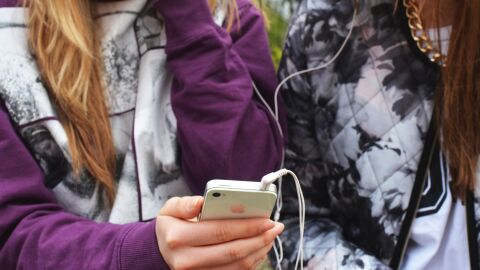 Unas j&oacute;venes con un tel&eacute;fono m&oacute;vil