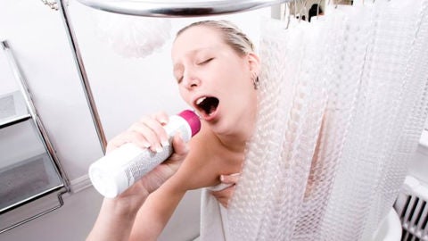 Una mujer cantando bajo la ducha
