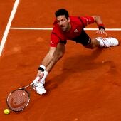 Novak Djokovic estirándose para alcanzar la pelota en Roland Garros