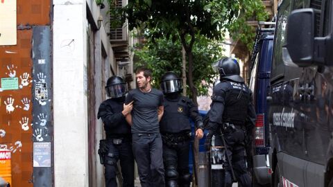 Los Mossos d'Esquadra custodian a uno de los okupas detenidos