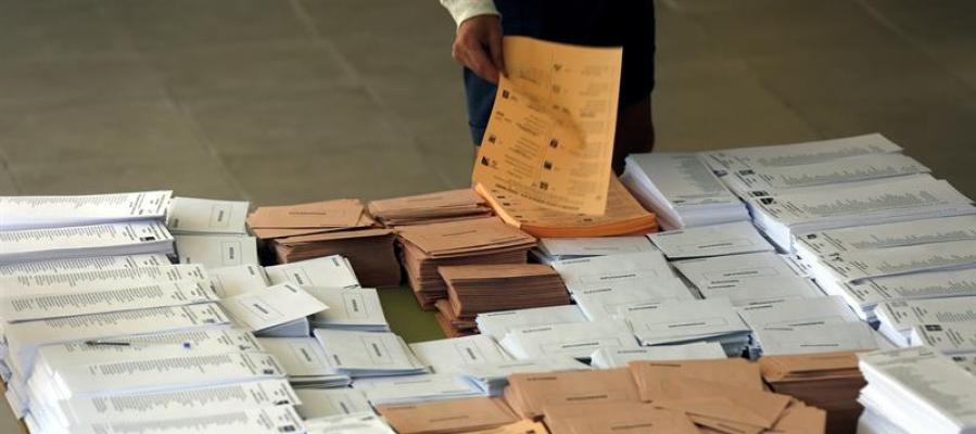 Un votante selecciona las papeletas antes de votar