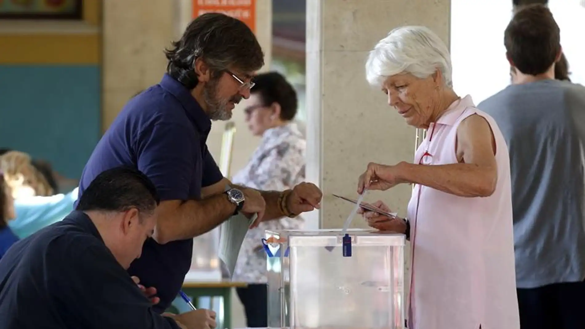 Una mujer deposita su voto en una urna de un colegio electoral
