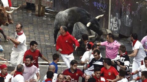  Los mozos corren en el tramo de Mercaderes ante los toros de la ganader&iacute;a abulense de Jos&eacute; Escolar Gil en el tercer encierro de los Sanfermines 2016.
