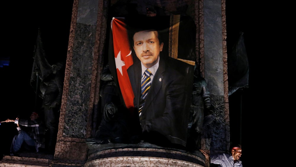 Un manifestante ondea una bandera con la foto del presidente turco Tayyip Erdogan durante una manifestación pro Gobierno en la plaza Taksim en Istanbul.