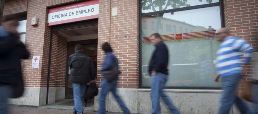 Varias personas entran a una oficina de empleo Varias personas entran a una oficina de empleo