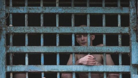 Dos prisioneros miran a trav&eacute;s de los barrotes de su celda en la prisi&oacute;n