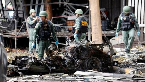 Integrantes del escuadr&oacute;n antiexplosivos de tailand&eacute;s EOD inspeccionan los restos de un veh&iacute;culo