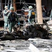 Integrantes del escuadrón antiexplosivos de tailandés EOD inspeccionan los restos de un vehículo
