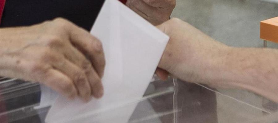 Una persona deposita su voto en unas elecciones Una persona deposita su voto en unas elecciones