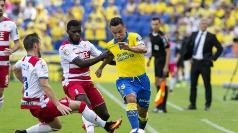 Roque Mesa disputa un bal&oacute;n con el defensa Roberto Rom&aacute;n, "Tito", del Granada, durante el partido frente a la UD Las Palmas