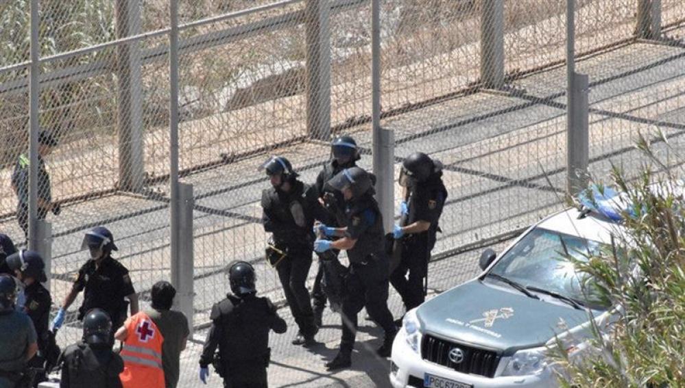 Varios agentes trasladan a un inmigrante en Ceuta