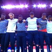 Los jugadores de los Knicks y de los Rockets, unidos durante el himno de Estados Unidos