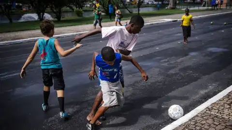 Niños jugando al fútbol en la calle Niños jugando al fútbol en la calle