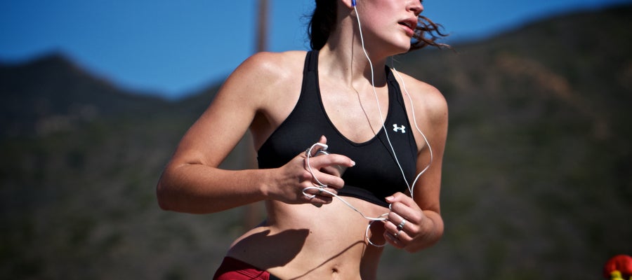 Una chica corre con auriculares Una chica corre con auriculares