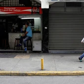 Un comercio abierto al lado de otro con las persianas cerradas Un comercio abierto al lado de otro con las persianas cerradas