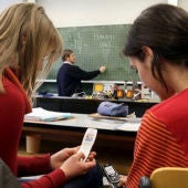 Dos alumnas utilizan sus teléfonos durante una clase