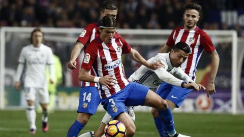 El portugu&eacute;s Cristiano Ronaldo (d), del Real Madrid, lucha el bal&oacute;n con el defensa brasiel&ntilde;o del Atl&eacute;tico de Madrid Filipe Luis