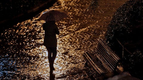 Joven con paragüas bajo la lluvia