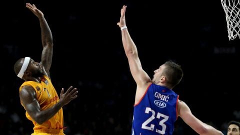 Rice lanzando a canasta frente a Omic