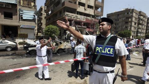 Un grupo de agentes de polic&iacute;a inspecciona el lugar donde un artefacto ha estallado en El Cairo 
