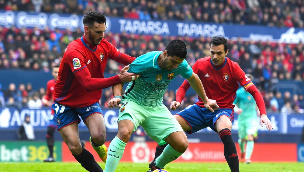 Luis Suárez intenta retener el balón ante la defensa de Osasuna