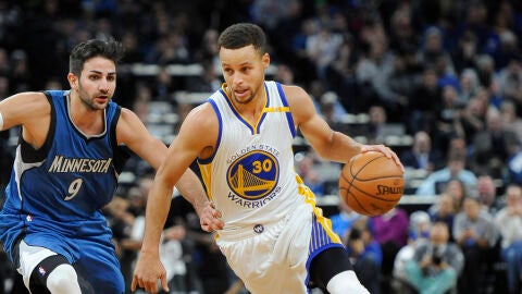 Stephen Curry corre con el bal&oacute;n mientras es defendido por Ricky Rubio