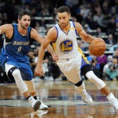Stephen Curry corre con el balón mientras es defendido por Ricky Rubio