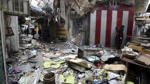 Varios iraqu&iacute;es inspeccionan el lugar del atentado registrado el pasado s&aacute;bado 31 de diciembre en el mercado Sinak, en el centro de Bagdad (Irak)