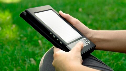 Un joven lee un libro electr&oacute;nico en su e-reader