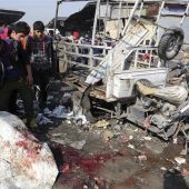 Iraquíes observan restos de sangre tras el atentado de esta mañana en Bagdad