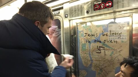 Un pasajero del metro de Nueva York elimina un mensaje de odio hacia jud&iacute;os en uno de los vagones