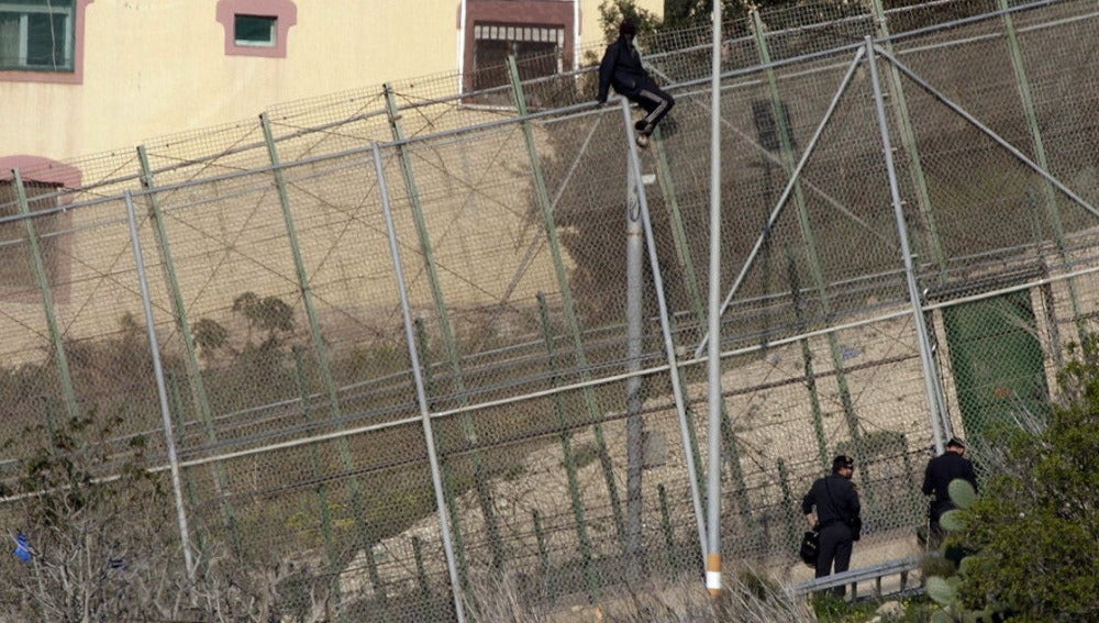 Un inmigrante en la zona alta de la valla de Melilla