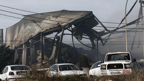 Los bomberos trabajan en la extinci&oacute;n del incendio en una nave de Paterna