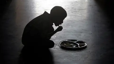 Un niño comiendo en un orfanato de la India Un niño comiendo en un orfanato de la India