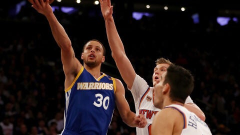 Curry hace una bandeja ante la defensa de Porzingis y Willy Hernang&oacute;mez