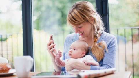 Una madre con su beb&eacute; mirando un smartphone